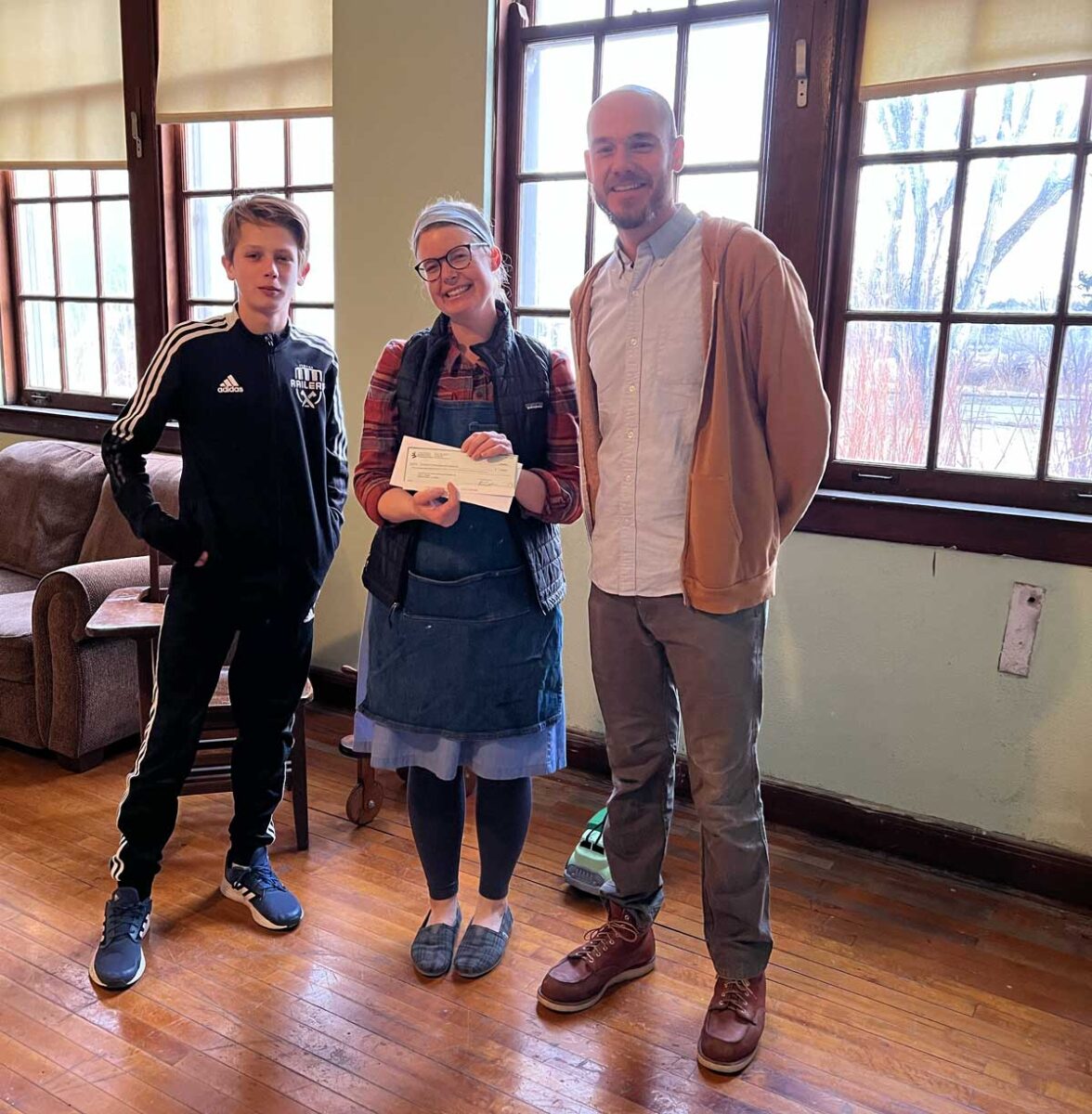 Collin Gaeddert presenting the Foundation award to Tia and Matt Regier at the School for Rural Culture and Creativity